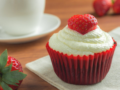 Close-up image of red velvet strawberry cup cake on coffee cup background with copy space, Valentine concept