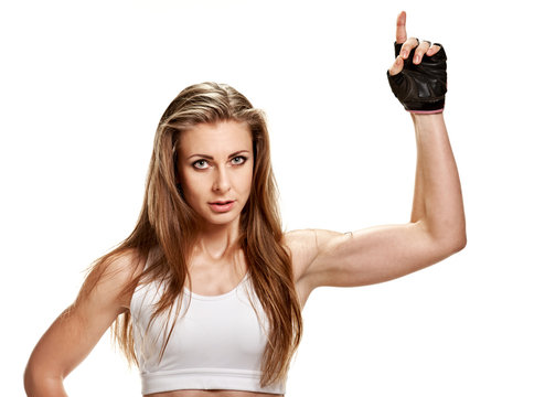 Sportswoman pointing up. Young strong athletic woman in gloves pointing up