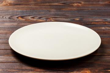 empty round plate for food on wood bachground. Perspective view