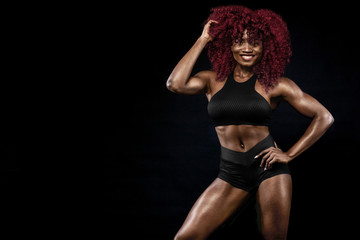 Fototapeta na wymiar Sporty beautiful afro-american model, woman in sportwear makes fitness exercising at black background to stay fit