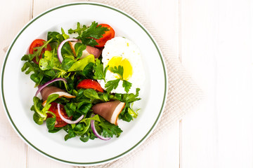 Fresh vegetable salad with ham and fried egg