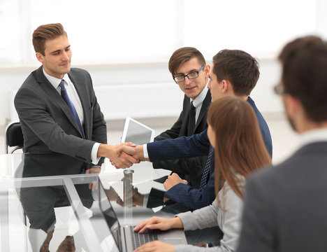 Businessmen making handshake in an office.