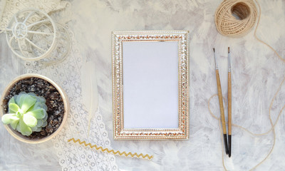 Vintage mockup. Succulent plant, vintage silver frame with place for text, lace, twine, brushes, bird's cage