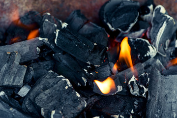 Black coals and orange flame - a fire close up