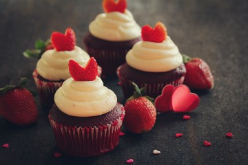 Homemade Valentines day red velvet cupcakes with strawberry heart frosting, selective focus