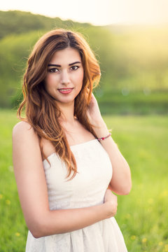 Young happy attractive woman posing in sunset