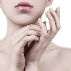 Obraz na płótnie Canvas Close up of attractive young woman gently touching her face with white background - cosmetic, wellness, manicure