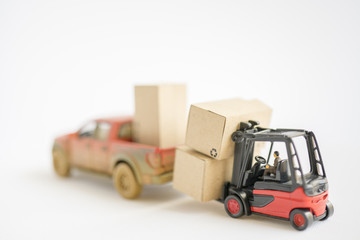 Miniature toy:Fork lift operator during lift product box to pick up . Transportation ,Business,Logistic concept.