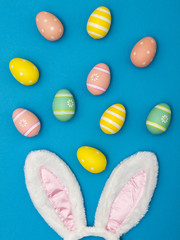 Easter holiday background with bunny ears and easter eggs on a blue background