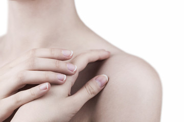 Close up of a woman's hands touching her shoulder - skin care, manicure, beauty treatment