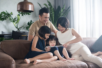 Happy Asian family using the computer together at home.