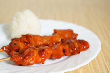 Thai-styled grilled chicken red sauces and sticky rice. It's among most popular street foods in Thailand.