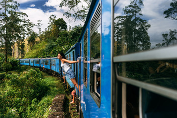The girl travels by train to beautiful places. Beautiful girl traveling by train among mountains....
