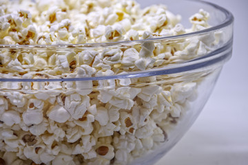 Popcorn in a transparent glass bowl close-up