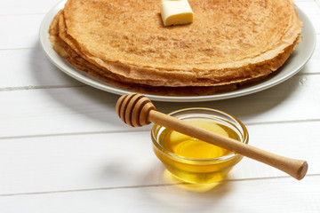 Stack of tasty pancakes with butter and honey for breakfast