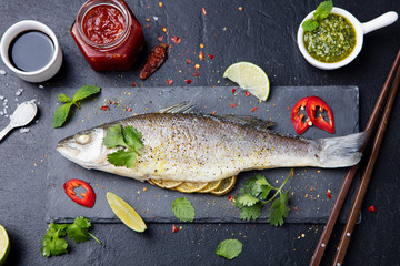 Roasted fish with sauces, fresh herbs and lime