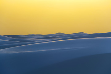 beautiful untouched white sand dunes bathed in stunning yellow light from sunset