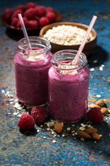 healthy berry smoothies with oatmeal on a dark background, vertical
