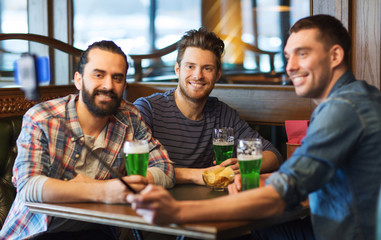 friends taking selfie with green beer at pub