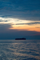 Container ship sail along the trade route in the evening before sunset