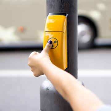 Blindes Kind dr&uuml;ckt auf Ampel-Taster f&uuml;r Sehbehinderte um &uuml;ber die Stra&szlig;e zu kommen
