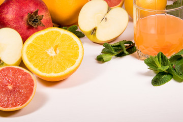 A vitamin set on a white background fruit and citrus apples grapefruit orange ginger mint and blander Healthy eating glass of juice copyspace