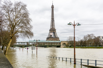 View of the swollen Seine during the winter flooding episode of January 2018, with the flooded expressway in the foreground and the Eiffel tower and Bir-Hakeim bridge in the background.