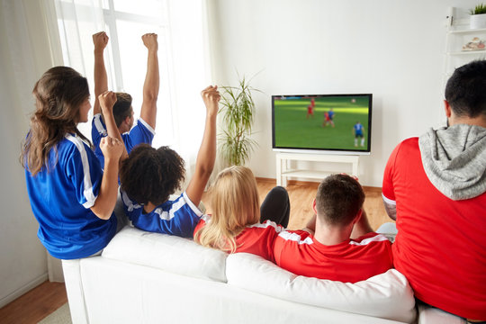 football fans watching soccer game on tv at home