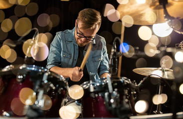 male musician playing drums and cymbals at concert
