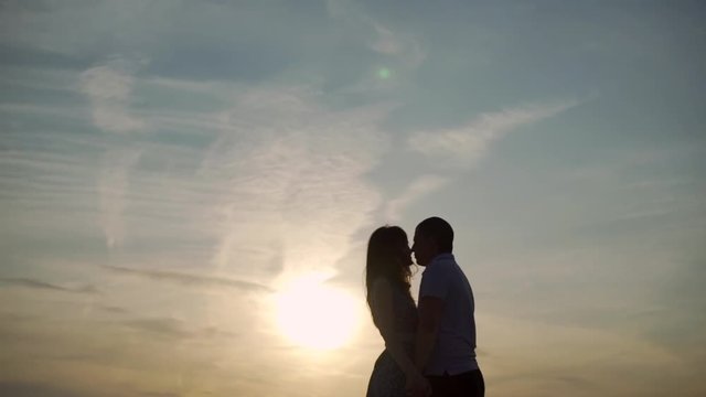 loving couple kisses at sunset