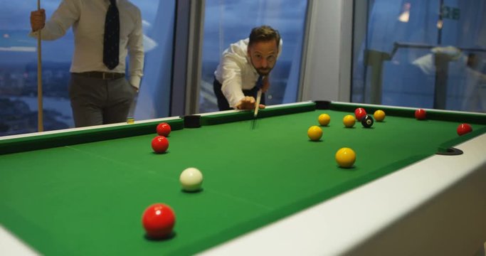 4k, Business people playing billiards after work in the evening. Slow motion.