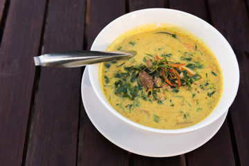 Spicy Curry crab with Piper sarmentosum in bowl on wooden table