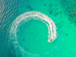 People are playing a jet ski in the sea.Aerial view. Top view.amazing nature background.The color of the water and beautifully bright. Fresh freedom. Adventure day.clear turquoise at tropical beach.