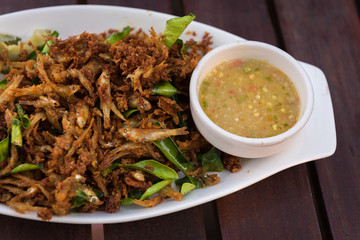 Minnows fish fried with sauce in white dish. Thai food