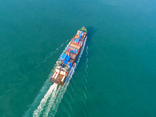 Container ship in export and import business and logistics. Shipping cargo to harbor by crane. Water transport International. Aerial view