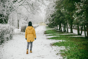 woman walk by park where winter meet spring