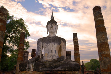 Obraz premium Ancient sculpture of the sitting Buddha close up at sunset. Historical park of the Sukhothai city, Thailand