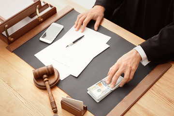 Male judge with bribe at table, closeup