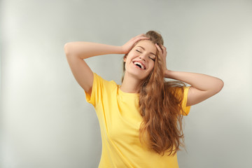 Fototapeta premium Portrait of beautiful smiling woman on light background