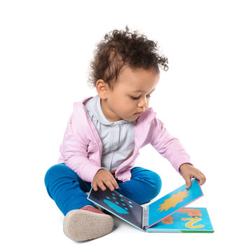 Cute little child with colorful book on white background