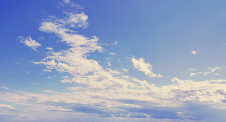 feathery clouds on the blue sky.