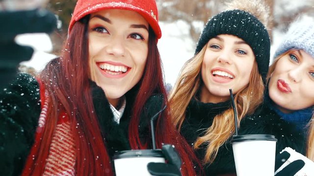 winter, technology, friendship and people concept - group of smiling women taking selfie outdoors