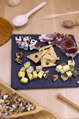 Appetizer for wine, different cheeses on a stone board, top view