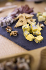 Yellow cheese, hard cheese with holes, different cheeses on a dark background