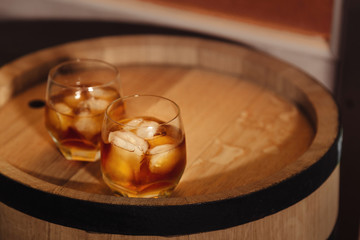Glass of whiskey on wooden background close up