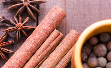 pepper peas with anise and cinnamon on brown wooden background.