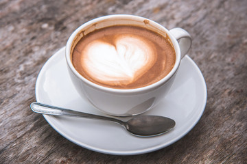 Cup of coffee on old wooden desk table background.