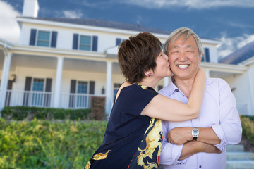 Happy Chinese Senior Adult Couple Kissing In Front Of Custom House.
