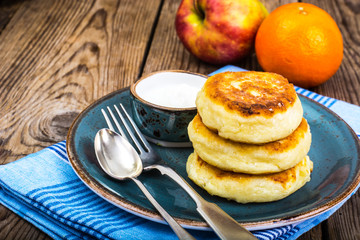 Hot delicious curd pancakes with fruit salad and yogurt