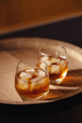 Glass of whiskey on wooden background close up